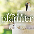 planner - Reinweiss Hochzeiten Wedding cake with bride and groom figurines and the text "Wedding Planner" in the foreground.